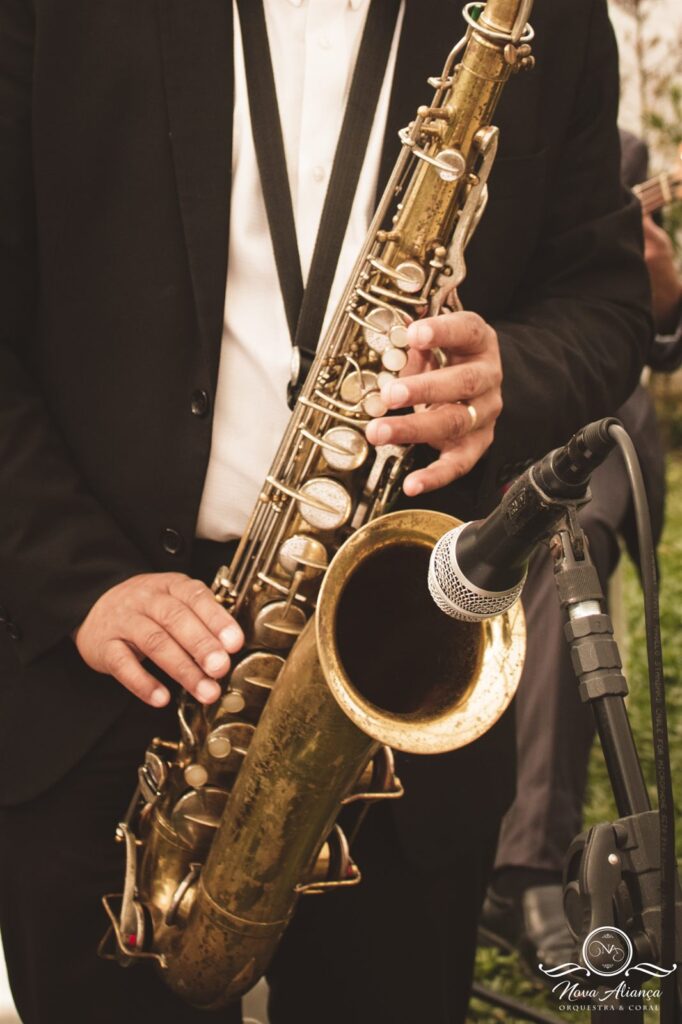 Saxofonista da Nova Aliança tocando com microfone em casamento